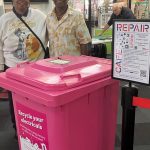 Pink recycling bin with customer and volunteer